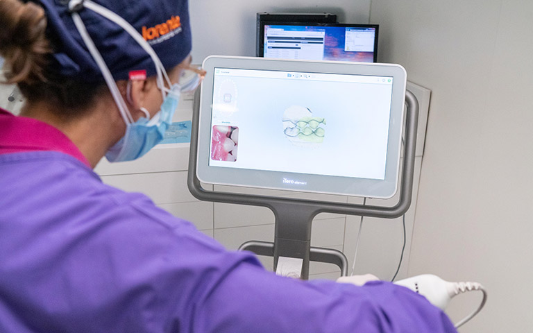 Doctora mira en pantalla agenesia dental en paciente